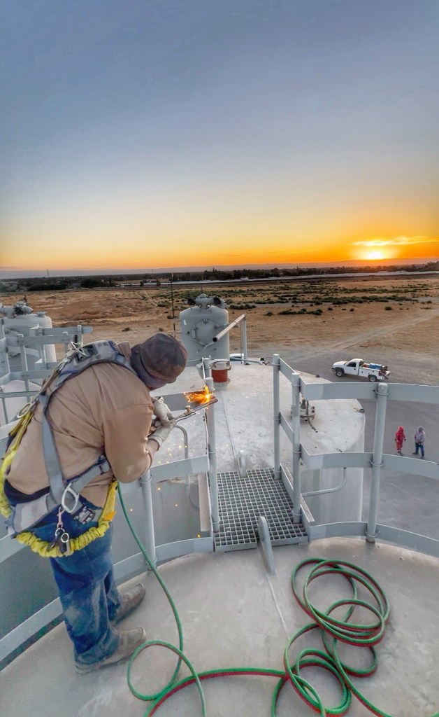Field welding work at an industrial site near sunset