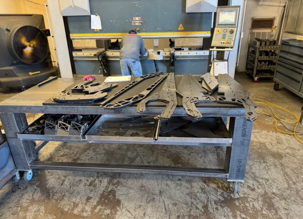 Operator forming steel plate on the shop press brake