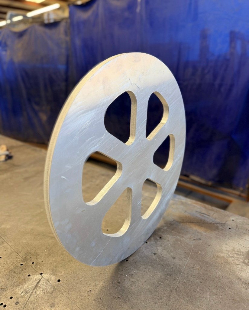 Circular laser-cut steel component with spoke cutouts