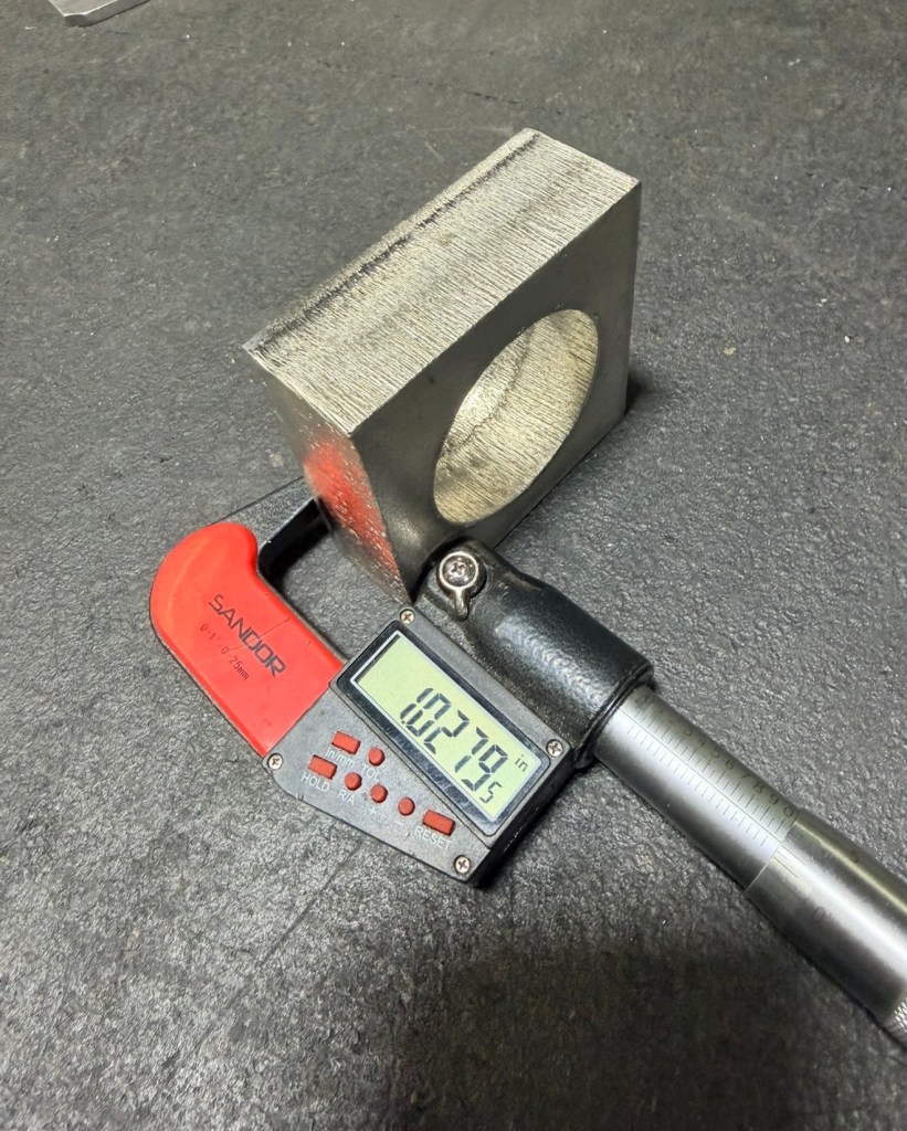 Digital caliper checking a laser-cut steel component