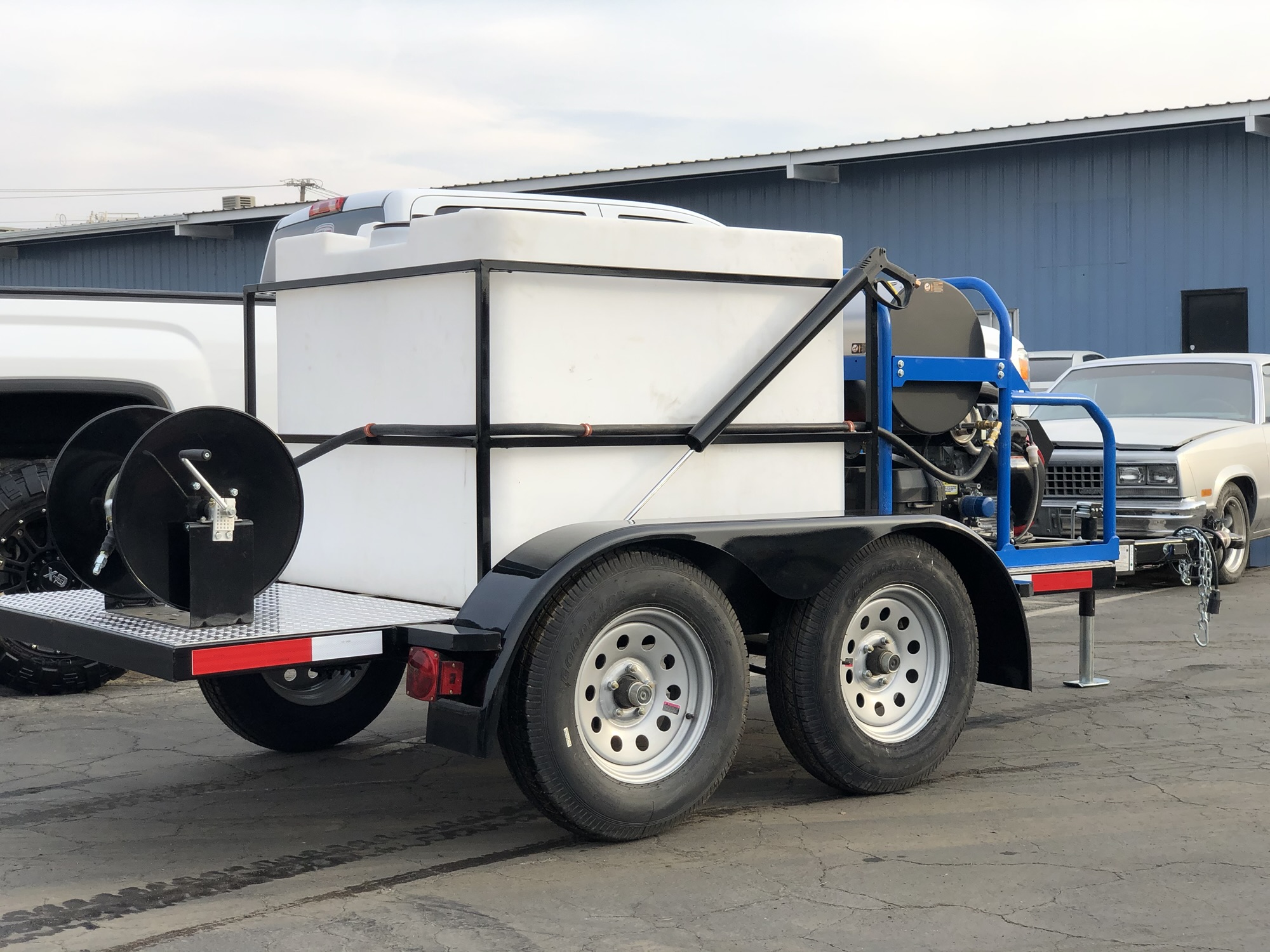 Side view of a tandem-axle pressure washing equipment trailer