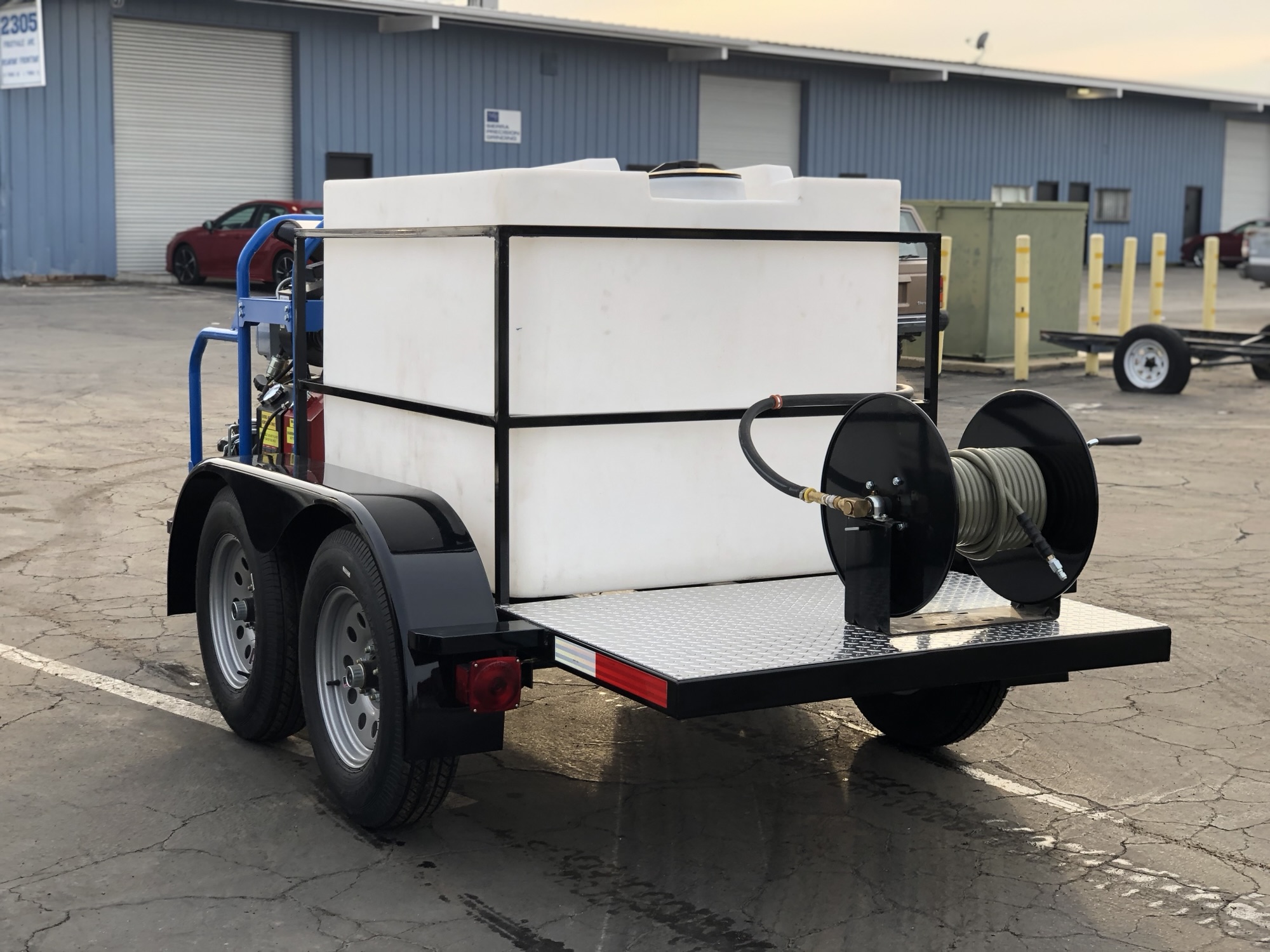 Rear view of a custom pressure washer trailer with water tank and hose reel