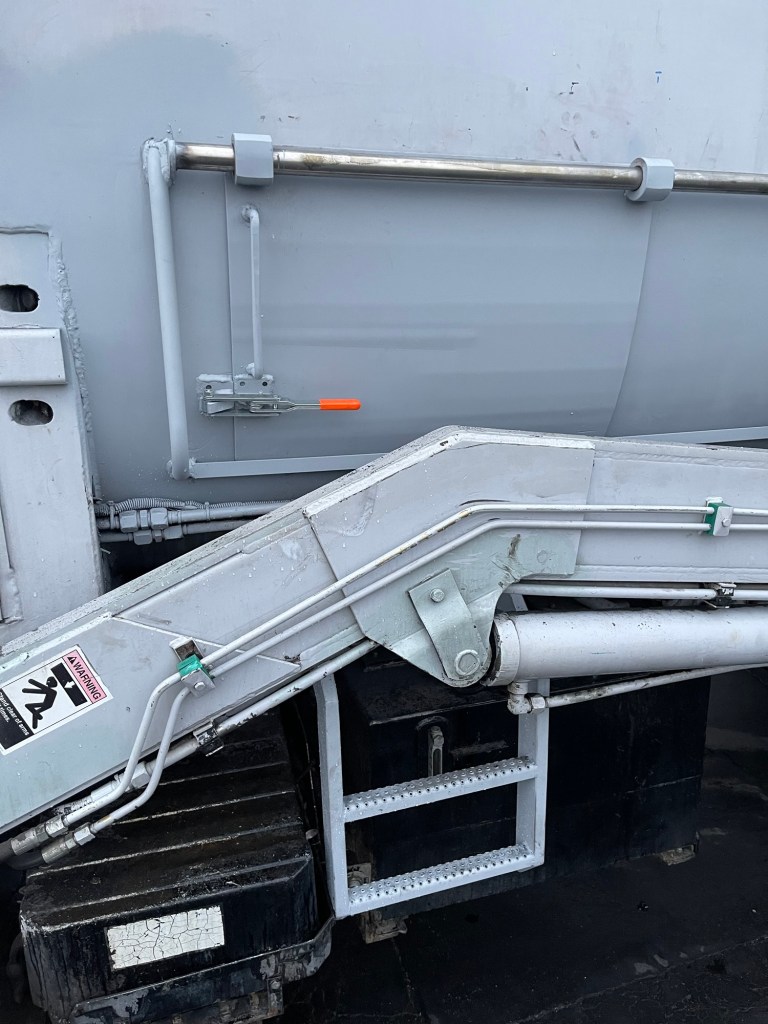 Repaired gray sanitation truck body and structural metalwork