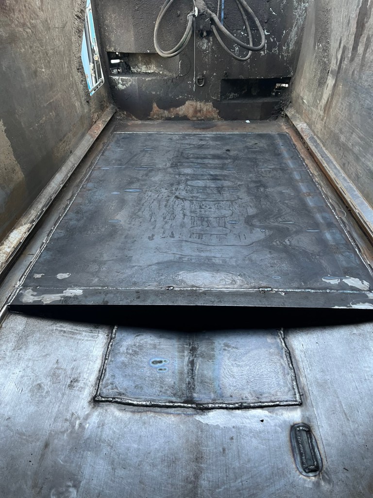 Interior metal repair work on a sanitation truck body