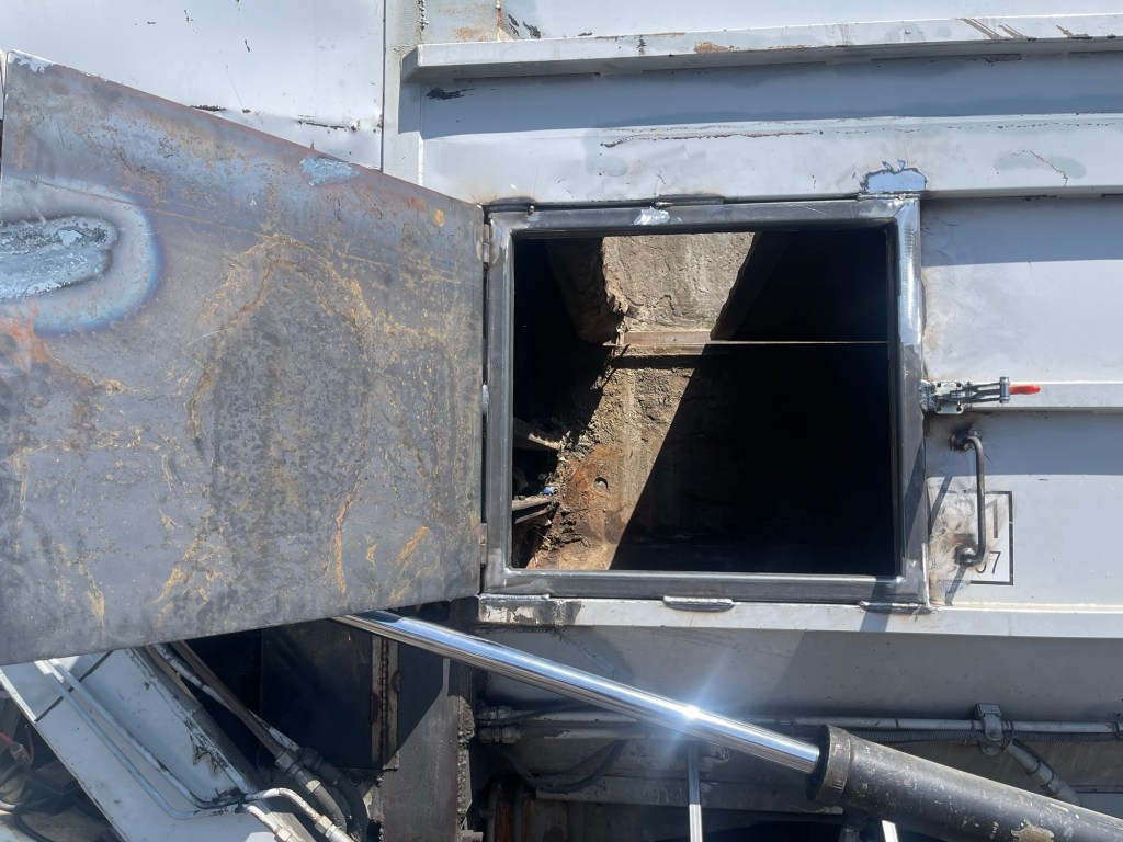 Cut opening and repaired steel panel on a sanitation truck body