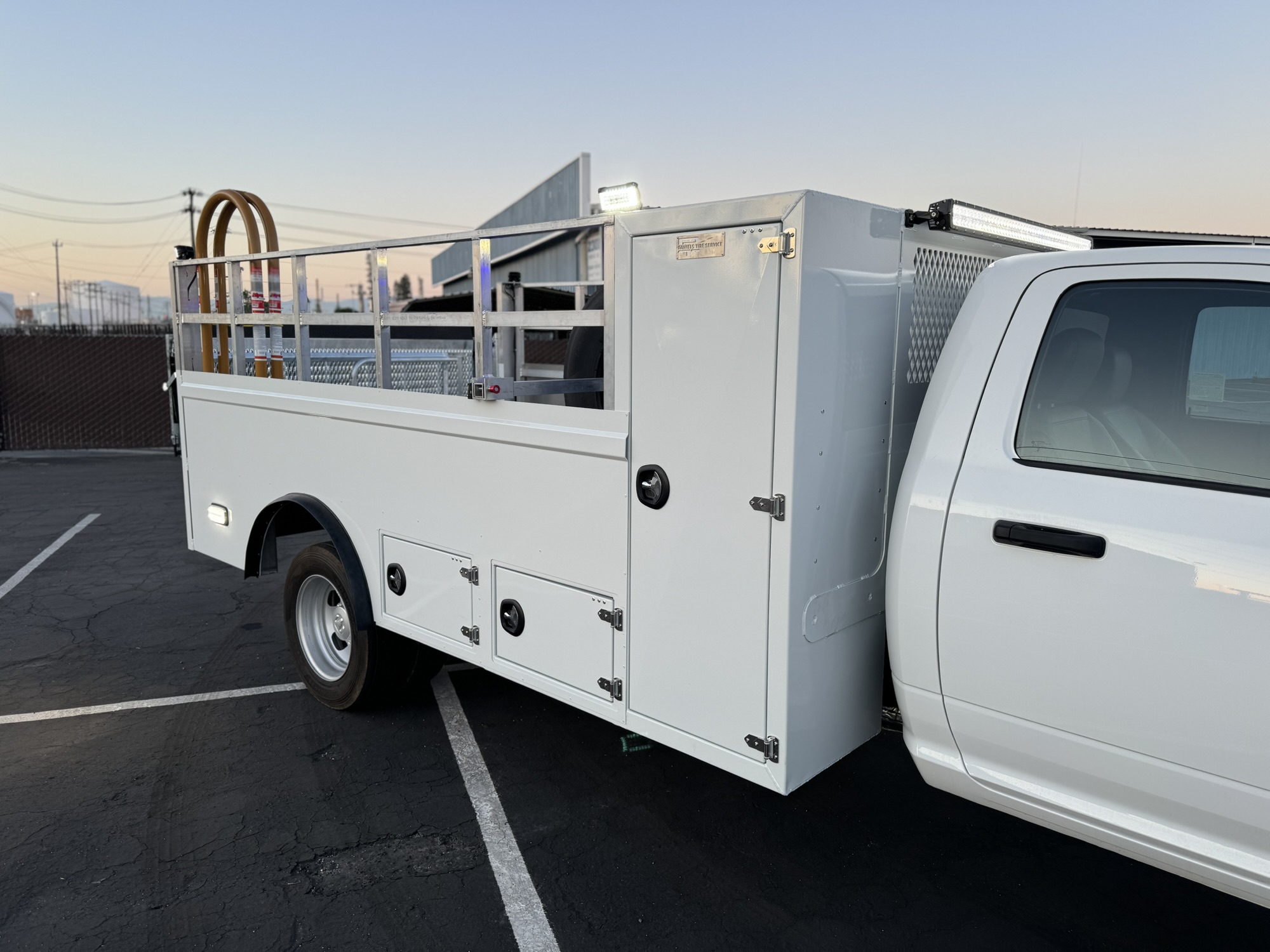 Tire service truck body with storage compartments and rack