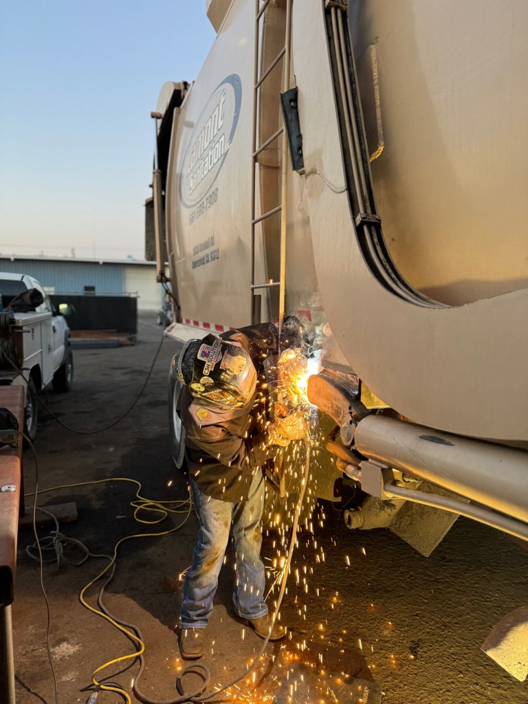 Welder repairing a sanitation truck body at C3H Solutions in Bakersfield
